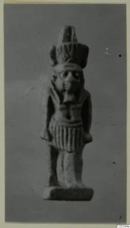 Small standing figure of Nefertum with a tall headdress, shown on a rectangular base