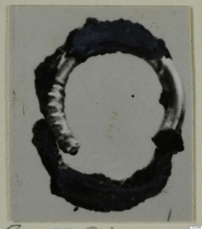 Hair-ring of gilded bronze from Marion Tomb 38, photographed close up on a grey card mount