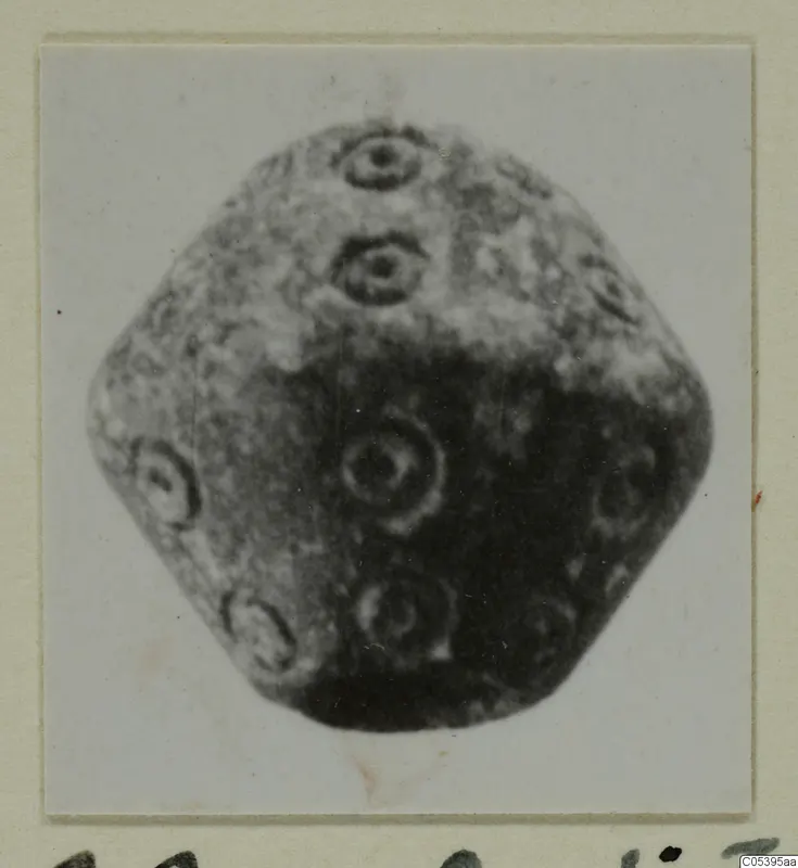 Many-faced stone object with ring-shaped decoration on its faces, from Amathus, photographed on a mounted card