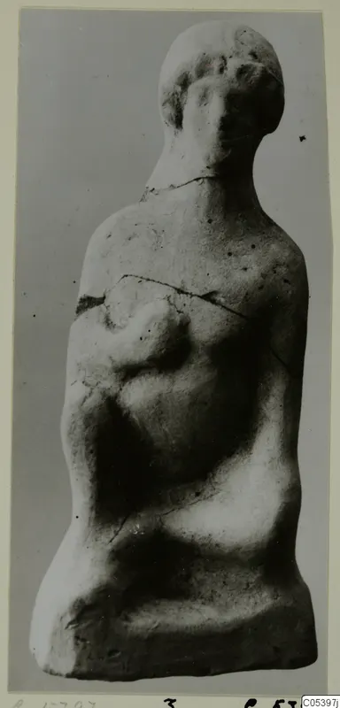 Terracotta figurine of a human figure with a rounded head and one arm across the chest, from the Marion finds