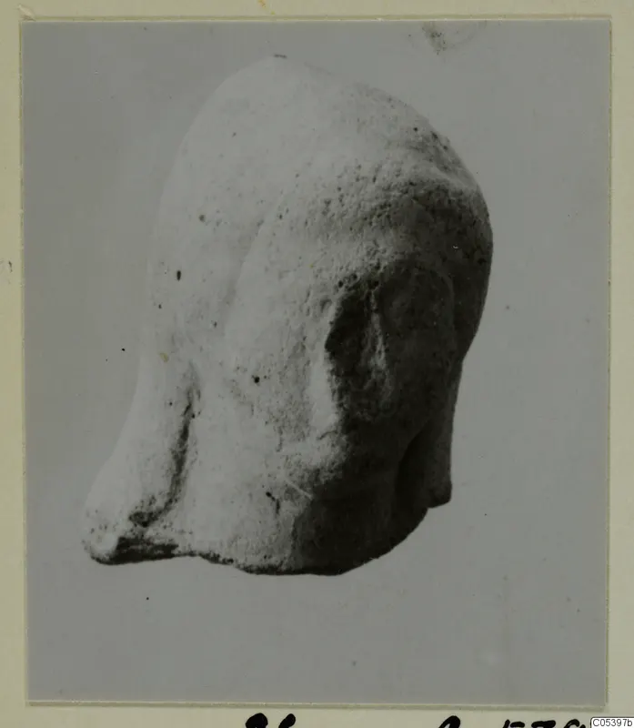 Terracotta head from Tomb 20 at Marion, photographed from a three-quarter view.