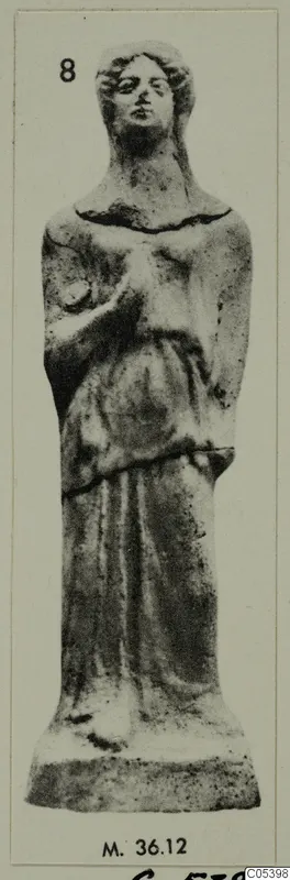 Figurine from Marion of a standing figure in a long garment with a raised hand