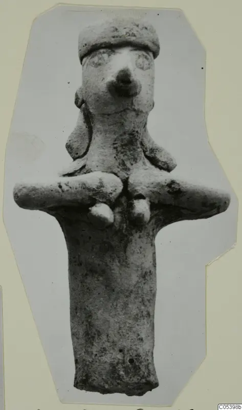 Terracotta figurine with a cylindrical body, arms stretched out to the sides and a flat-topped head with a large nose.