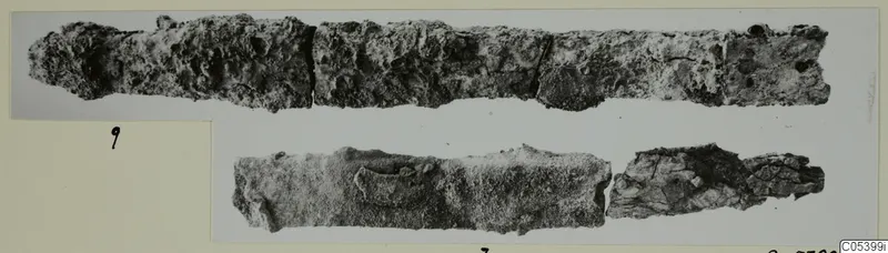 Two corroded iron tool fragments from Marion Tomb 27, shown on a mounted photograph