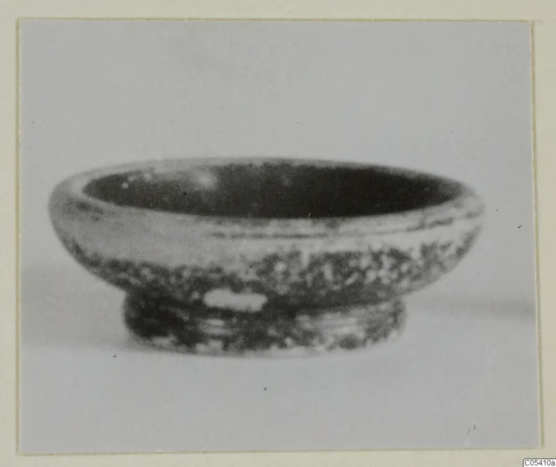Small pottery bowl with a rounded body and low ring foot, seen from the side