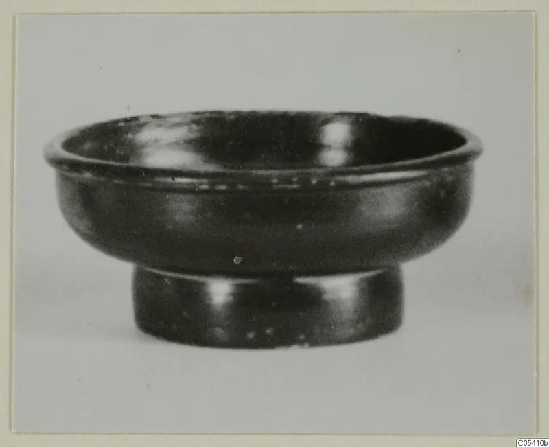 Black glazed ware bowl with a short ring foot, seen from the side