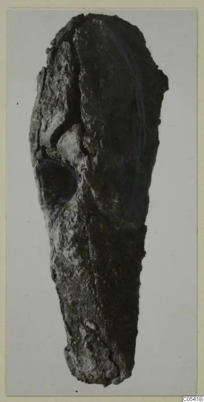 Heavily corroded iron tool from Amathus, elongated with a rounded socket-like opening near the upper end.