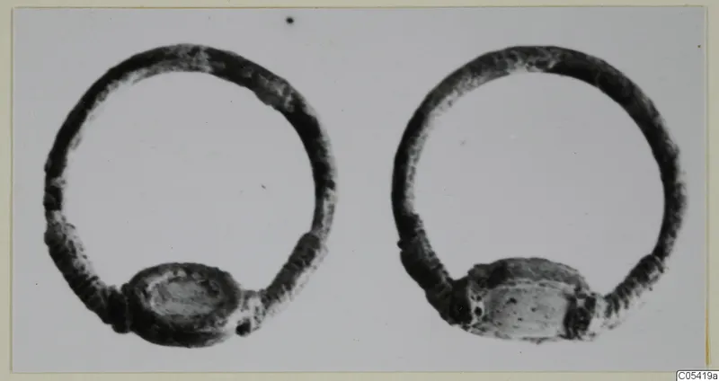 Two silver rings with flat oval settings, side by side on a pale background.