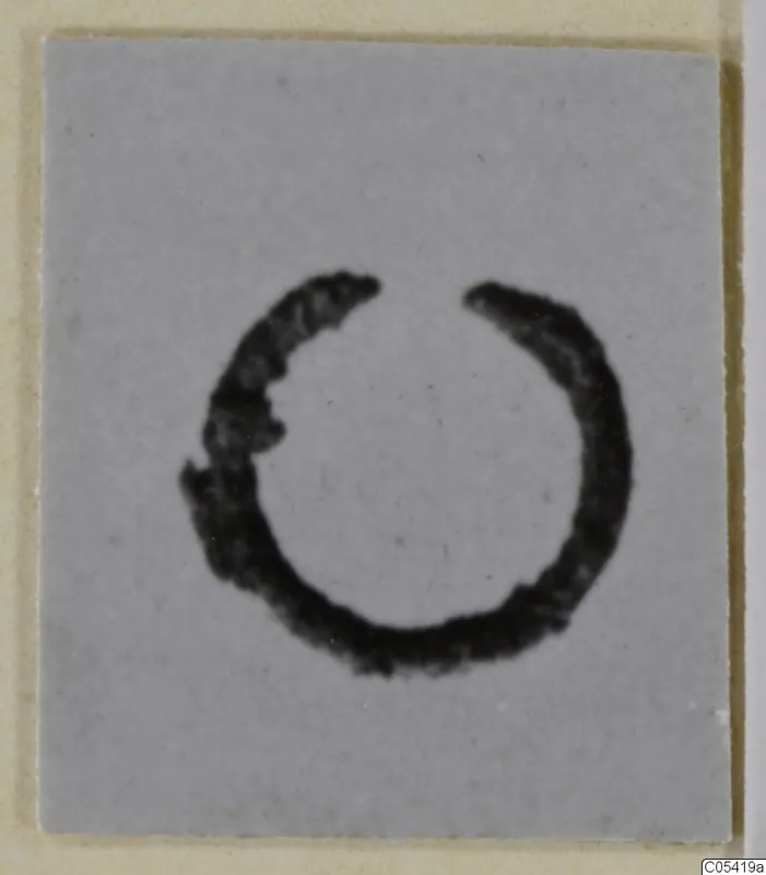 Open bronze ring of personal adornment on a grey card.