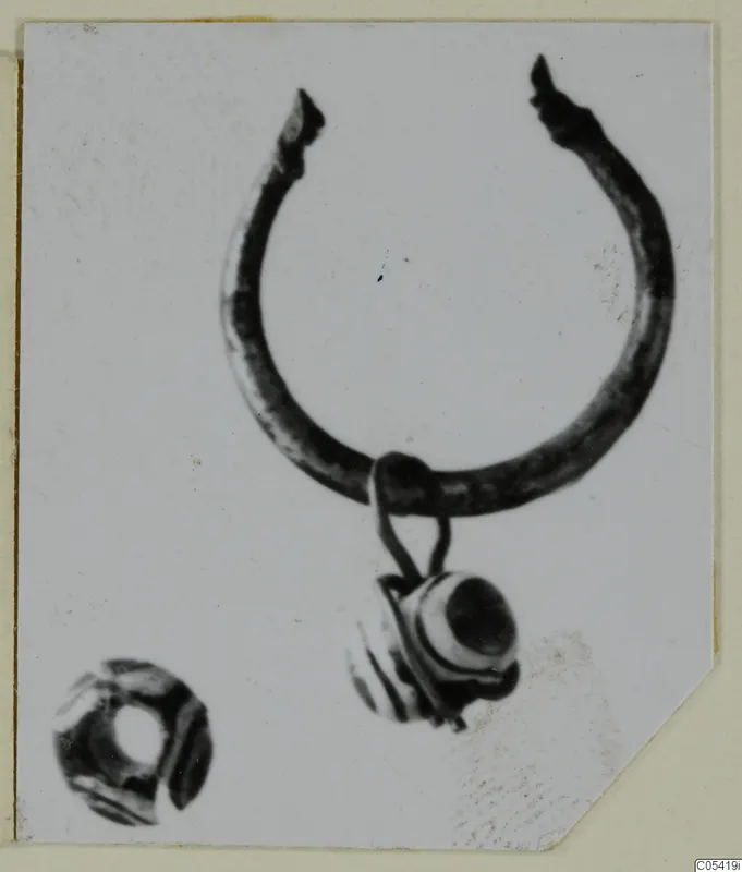 Silver ring with a bead pendant on a loop, and a separate small bead at lower left