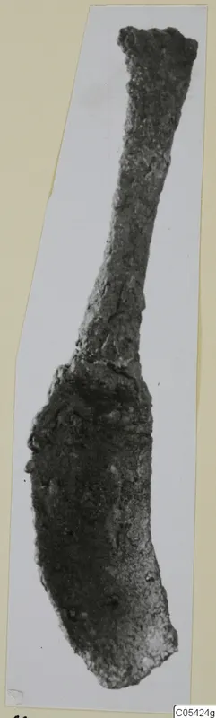Corroded iron strigil from Marion, long and narrow with a broadened, curved end.