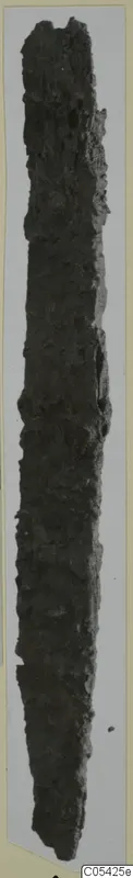Long, narrow, heavily corroded iron tool from Marion, shown upright against a pale backdrop.