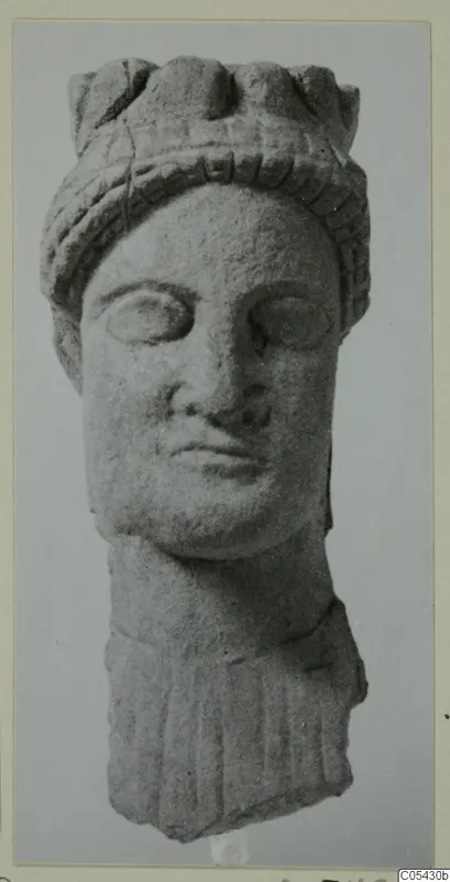 Carved limestone head of a statue from Mersinaki, with a ridged headdress and a fragment of drapery below