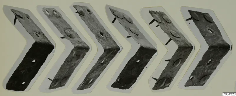 Six bent metal plates with protruding nails from Marion, arranged in a row on pale card.