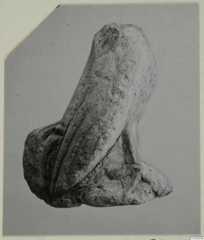 Limestone fragment of a small figure from Mersinaki, with parallel vertical grooves down one side