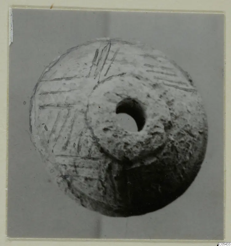 Spindle whorl of tufa from Marion Tomb 68, with incised lines on one face