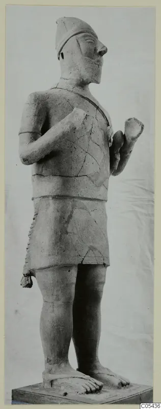 Terracotta statue of a standing male figure in a cap and fringed skirt, from Ayia Irini