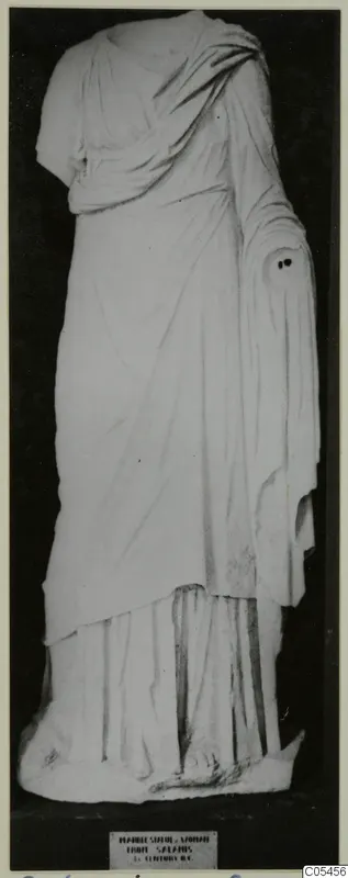 Marble statue of a standing draped woman from Salamis, head missing and one arm broken off at the shoulder.