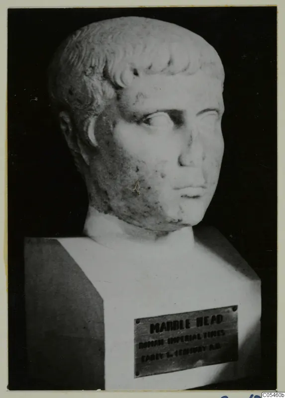 Marble head with short, curled hair, turned slightly to one side, on a square block base