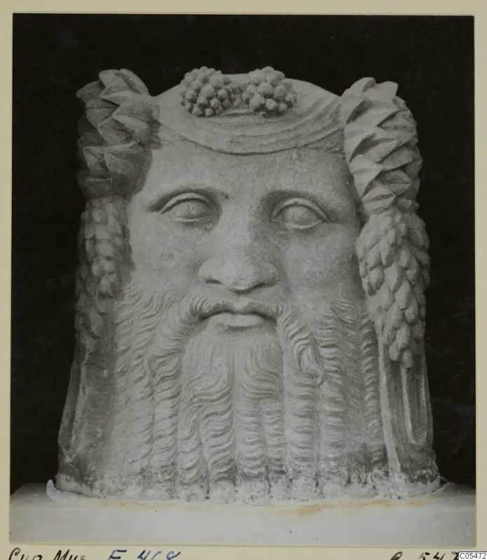 Stone head of a bearded man with curled locks and clusters of grapes on top, Cyprus Museum E. 468