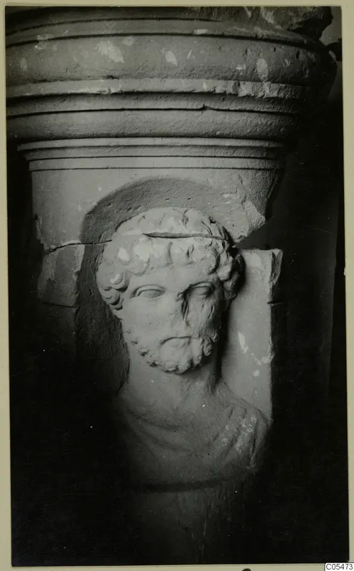 Carved stone head of a bearded man in relief below a moulded cornice, from Cyprus