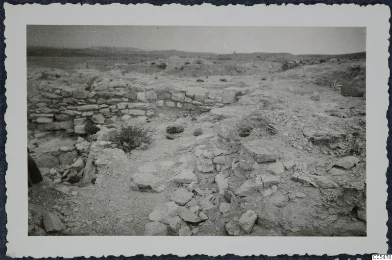 Excavated area at Idalion acropolis, with low stone walls and scattered rocks and rubble in dry ground