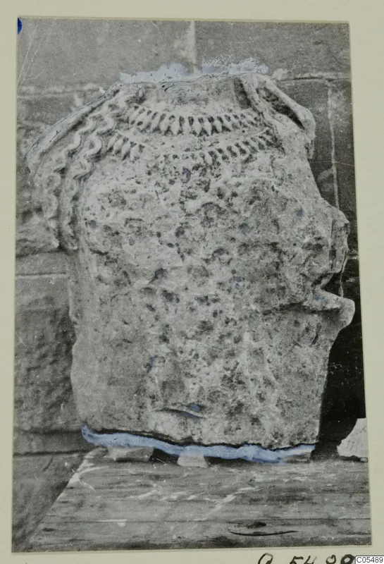 Stone statue from Arsos, shown in profile with carved ridged ornament across the top.