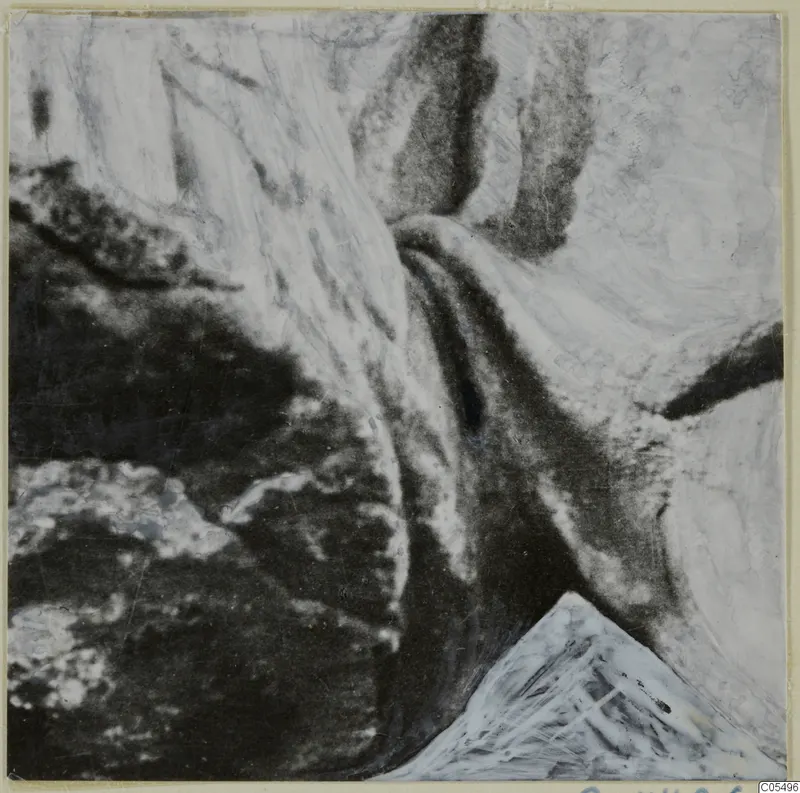 Close view of a marble sculpture surface with deep folds and dark hollows against pale raised areas
