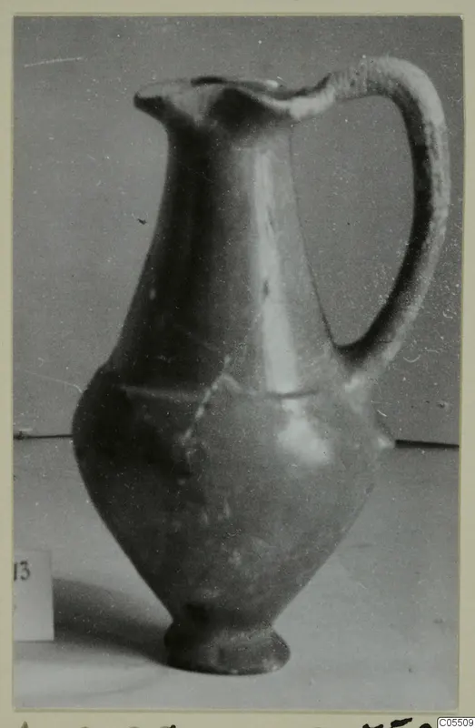 Red slip jug from Amathus, tombs 10–26, photographed against a grey backdrop