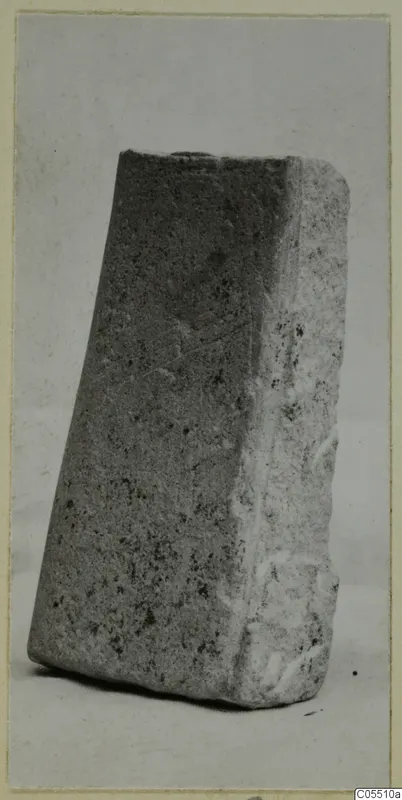Worked stone block from Petra Tou Limniti, a squared piece of grey speckled stone photographed against a plain background.