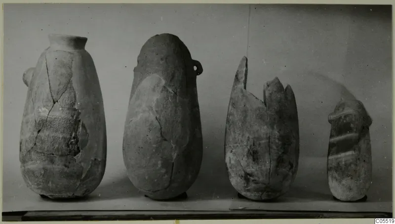 Four alabaster vases from Amathus standing in a row, photographed against a plain grey backdrop