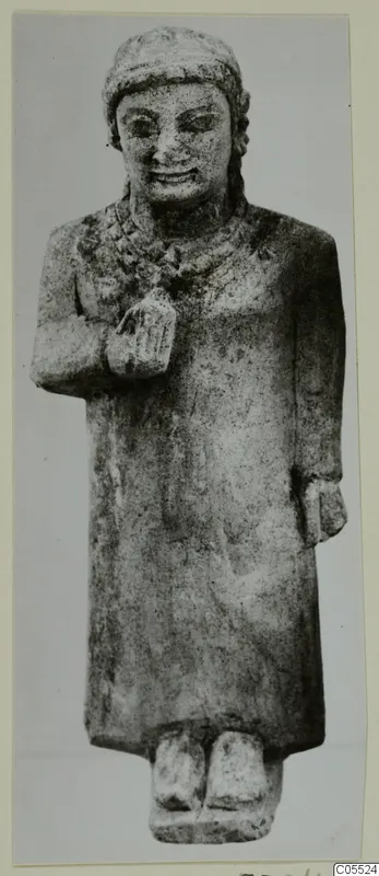 Limestone standing figure from Mersinaki in a long robe, one hand raised to the chest.