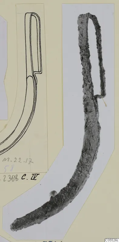 Corroded iron curved tool with a looped top, photographed beside a line drawing of the same object