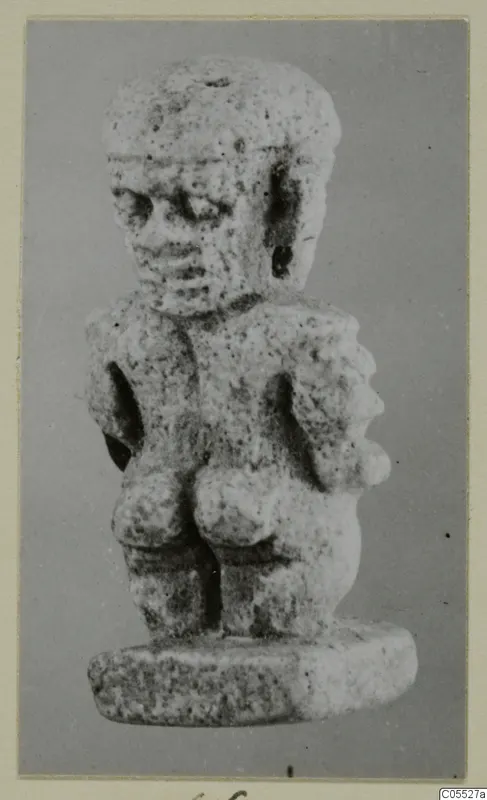 Small pitted stone figurine of a standing figure on a thick oval base, from Amathus
