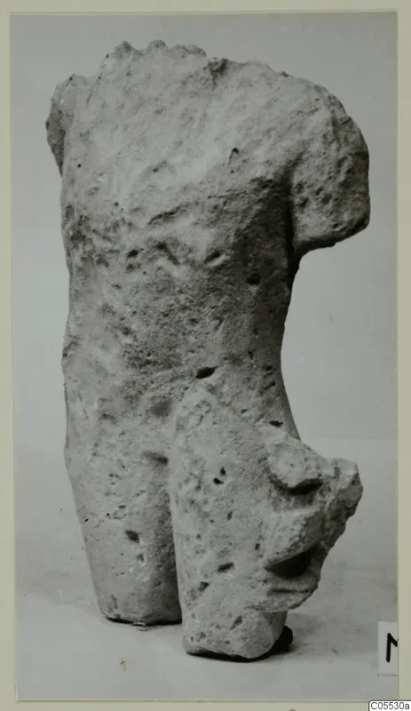 Fragment of a limestone figure's upper body and hips from Mersinaki, on a plain background