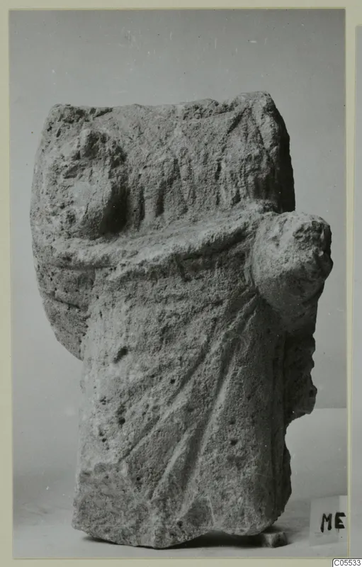Limestone sculpture from Mersinaki showing a draped figure with worn, carved folds and a rounded projection at one side