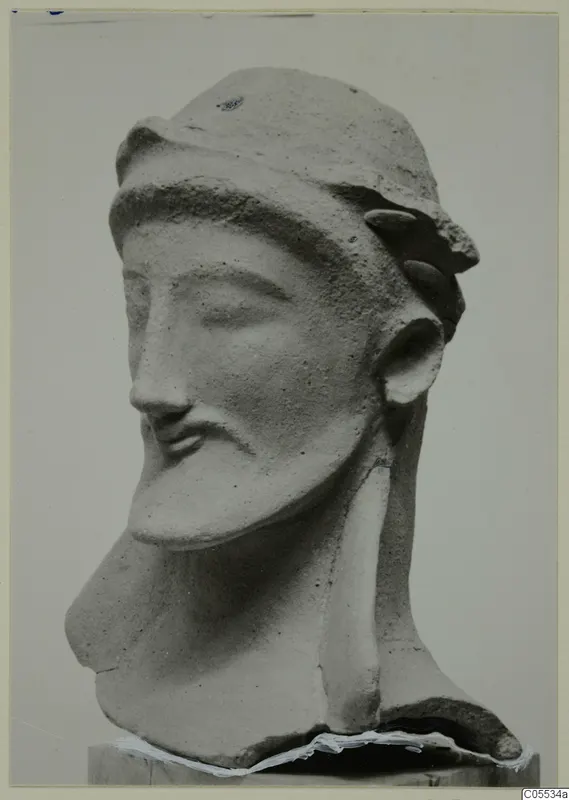 Terracotta head of a bearded man from Mersinaki, neck broken, standing on a wooden block