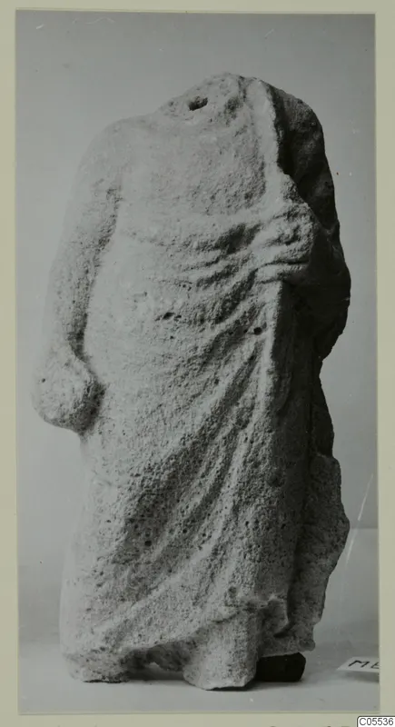 Headless draped limestone statue from Mersinaki, a standing figure with deep folds of cloth over the body