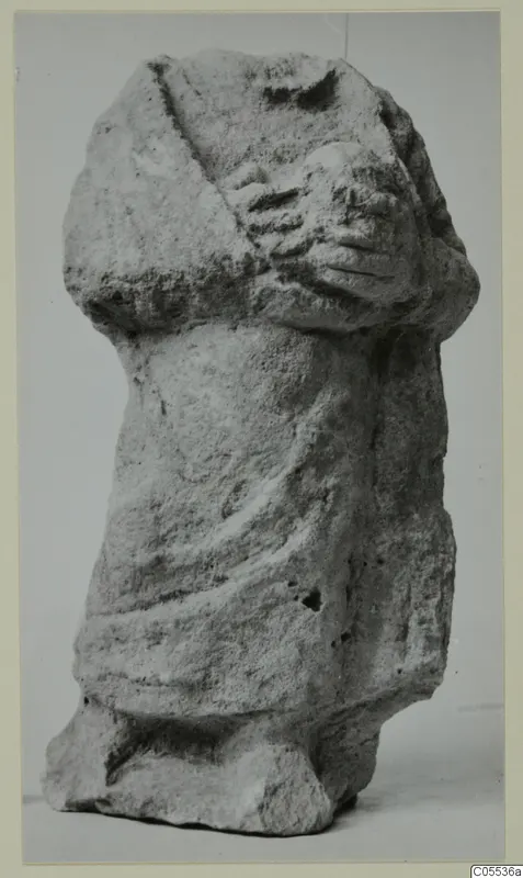 Limestone sculpture of a draped standing figure with arms folded across the chest, from Mersinaki
