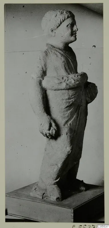 Standing limestone statue of a draped figure from Mersinaki, shown in profile on a wooden base.