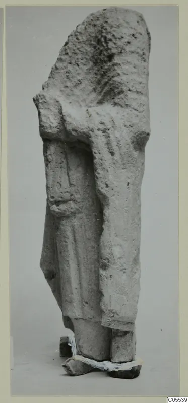Limestone sculpture fragment of a standing figure from Mersinaki, photographed against a grey backdrop