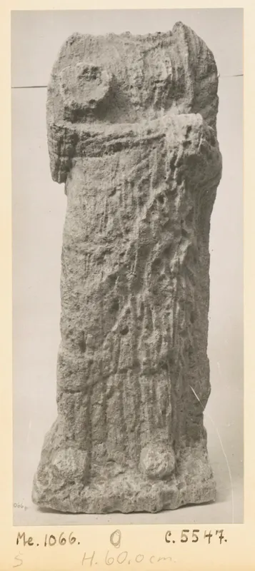Eroded limestone sculpture of a standing figure from Mersinaki, photographed upright on a grey backdrop