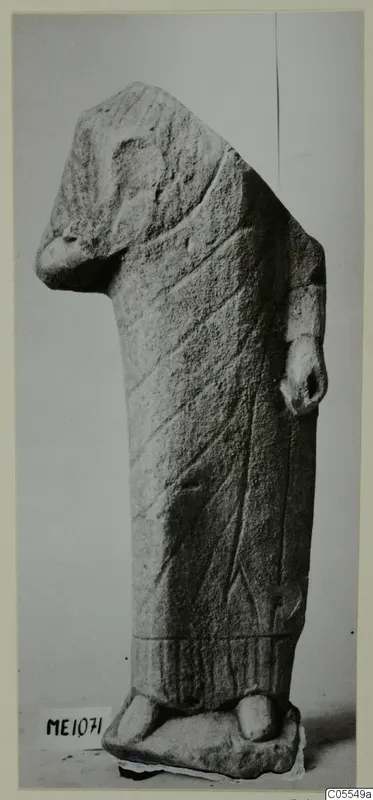 Limestone statue of a standing figure from Mersinaki, with incised lines on a long garment and a broken upper part