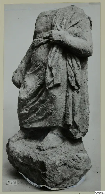 Headless draped stone statue from Mersinaki, arms held across the chest, standing on a rough block base