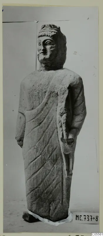 Limestone statue from Mersinaki of a standing figure in a draped garment, head and body shown
