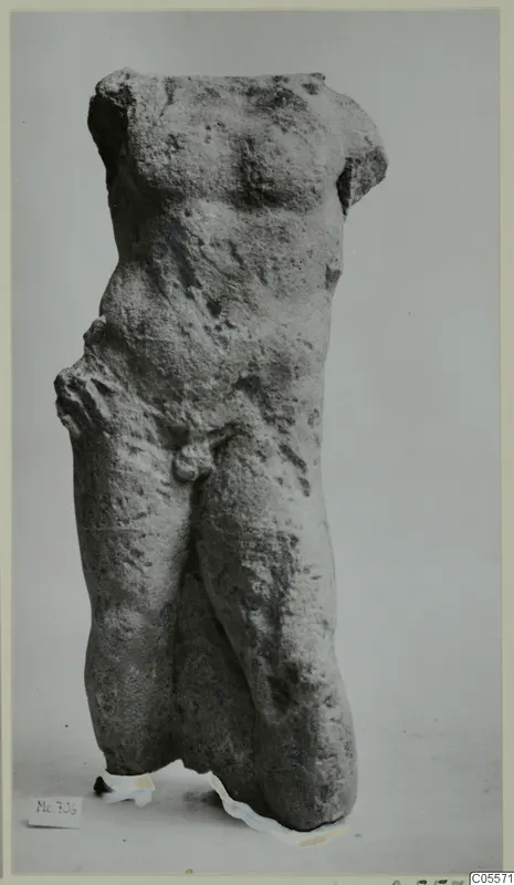 Weathered stone torso of a standing male figure from Mersinaki, with head and arms missing