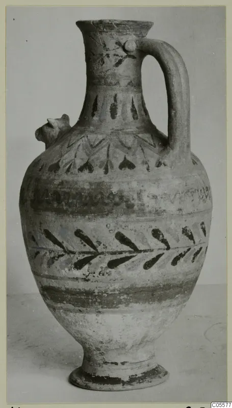 Pottery Polychrome III-VII jug with a strap handle, a small modelled projection on the shoulder and dark painted bands and leaves.