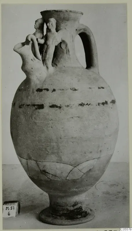 Pottery Polychrome jug with modelled figures on the neck and shoulder and dark painted bands on the body