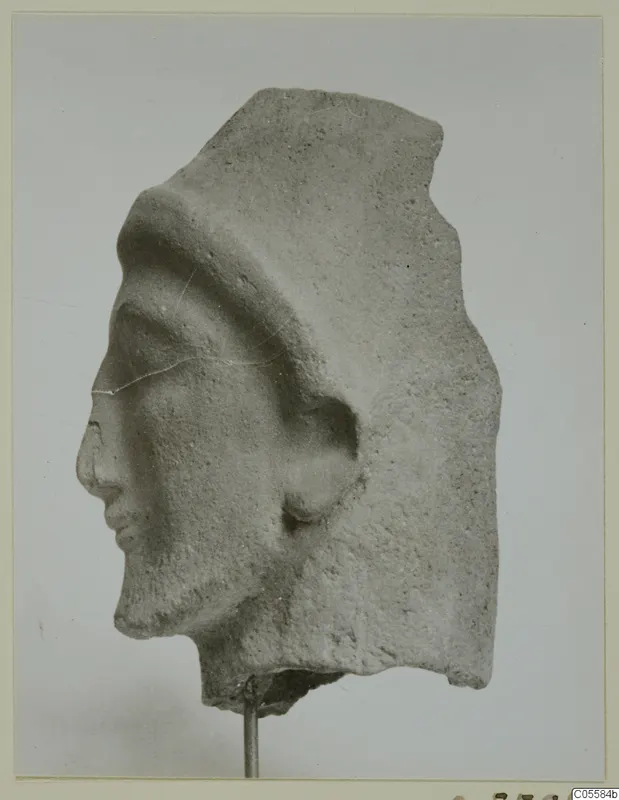 Fragment of a carved head in left profile, with a raised band across the top of the head