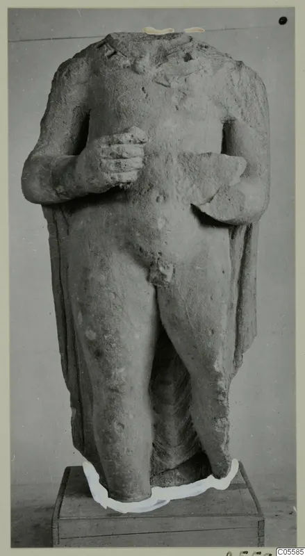 Headless standing male statue in limestone from Mersinaki, shown frontally on a wooden box base
